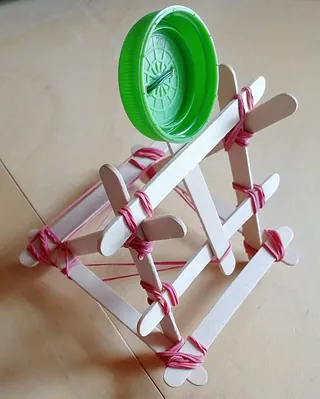 Bastelarbeit aus Eisstielen mit Faden.