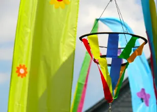 Bunte Bänder und Deko im Freien vor blauem Himmel.